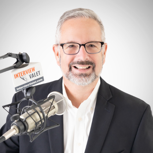 Image of Tom Schwab in front of a podcast microphone